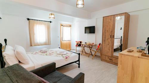 a bedroom with a bed and a couch and a table at MASAL SUİTES ESKi DATÇA in Datca