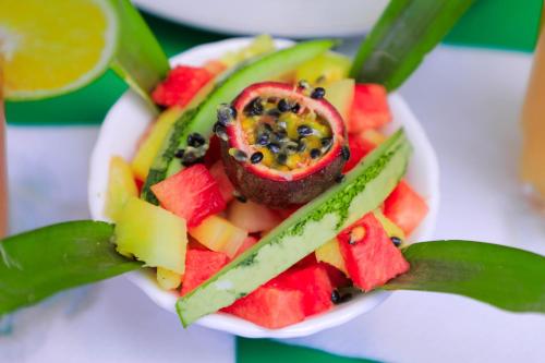a plate of fruit and vegetables on a table at Royal Park Hotel in Jinja
