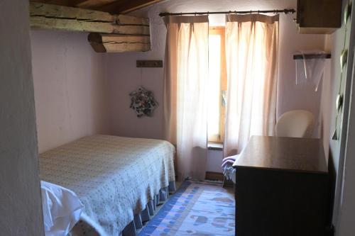 ein kleines Schlafzimmer mit einem Bett und einem Fenster in der Unterkunft Via S Cecilia 30 Urbania in Urbania
