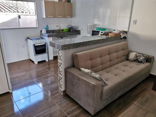 a living room with a couch and a kitchen at Casa do Diogo in Capitólio