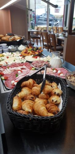 Una mesa cubierta con una cesta de croissants y pasteles. en Landhotel Wolf-Mertes, en Sessenbach