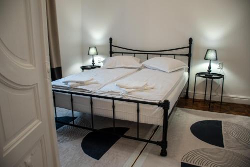 a bedroom with a bed with white sheets and pillows at Allegro apartments city center in Oradea
