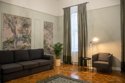 a living room with a couch and a chair at Allegro apartments city center in Oradea