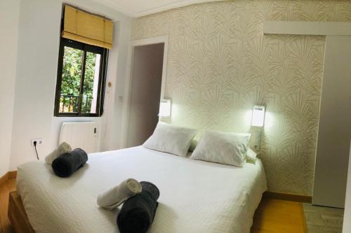 a bedroom with a large white bed with two pillows at El Escondite de la Muralla in Cáceres