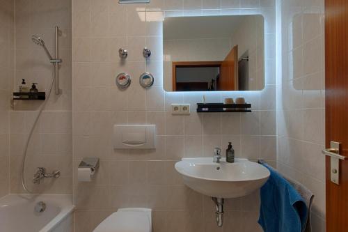 a bathroom with a sink and a toilet and a mirror at LaMiaCasa Balcony Parking Bosch Airport in Renningen