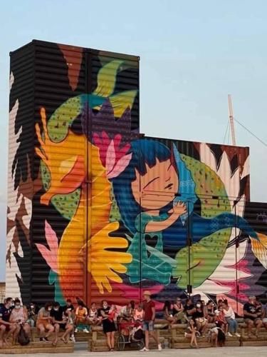 a crowd of people standing in front of a building with a mural at Residence Atlantis- Le Barcarès in Le Barcarès