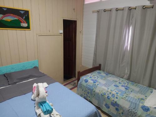 sypialnia z dwoma łóżkami i pluszowym zwierzęciem leżącym na łóżku w obiekcie Pousada Recanto da Mada Alter w mieście Alter do Chao