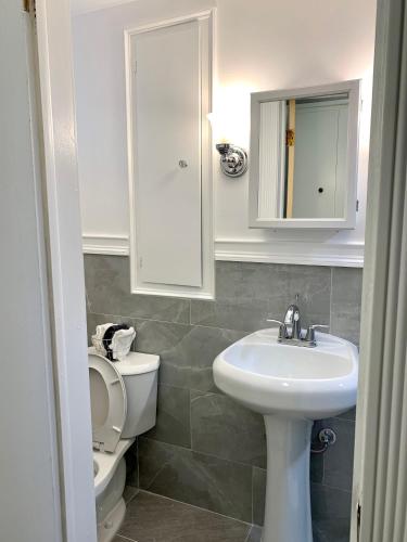 a white bathroom with a sink and a toilet at Large 7BR,4BA, Short walk to Niagara Falls in Niagara Falls