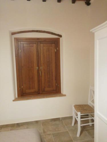 a living room with a cabinet and a chair at Laura Chianti Vacanze in Poggibonsi