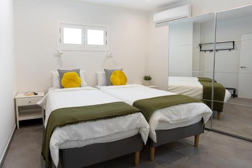 2 camas en una habitación blanca con espejo en HD Mogán Canal Apartments, en Puerto de Mogán