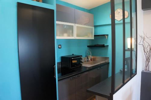 uma cozinha com um lavatório e um micro-ondas em Charmant appartement avec vue face mer imprenable em Mers-les-Bains