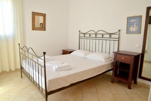 una camera con letto, comodino in legno e letto sidx sidx. di Trypiti Sea View Apartment a Tripiti