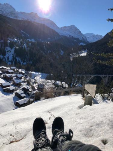 a person sitting on top of a snow covered mountain at Sonniges Chalet Arosa für 6 Pers alleinstehend mit traumhaftem Bergpanorama in Langwies