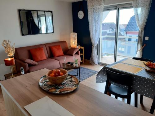 a living room with a couch and a table with a bowl of fruit at Studio 1 - 4 pers à 300m de la plage avec vue mer in Stella-Plage