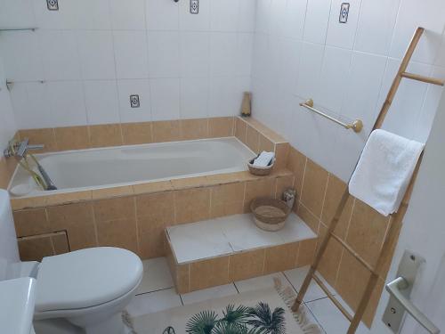 a bathroom with a tub and a toilet and a sink at Le Biabiany in Bouillante