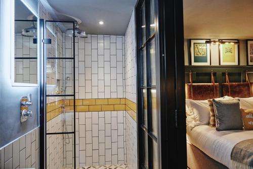 a bathroom with a glass shower and a bed at Kings Arms - Egham-Windsor in Egham