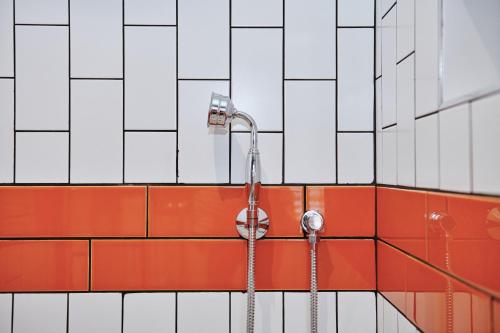 a shower in a bathroom with red and white tiles at Kings Arms - Egham-Windsor in Egham