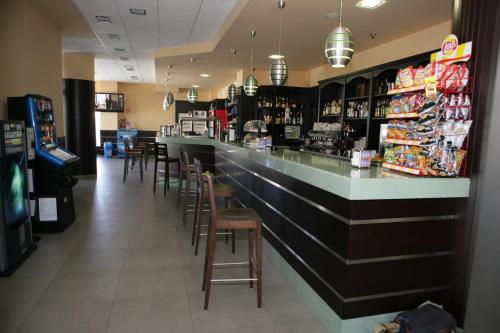 a bar in a restaurant with stools and a counter at HOTEL BRUMA II in La Gudiña