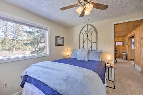 a bedroom with a bed with a ceiling fan and a window at Cozy CO Rocky Mountain Retreat Near Pikes Peak! in Green Mountain Falls