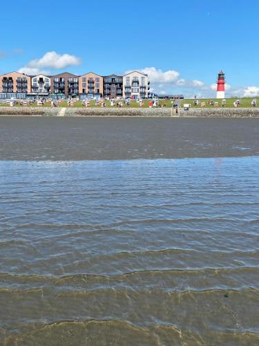 a body of water with a lighthouse in the background at Capt'n Eike in Westerdeichstrich