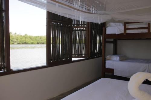 a room with two bunk beds and a window at Hostal Casa en la Ciénaga Rincon del Mar in Rincón