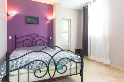 - une chambre avec un mur violet et un lit dans l'établissement Primavera, à Avignon