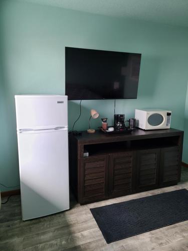 a white refrigerator next to a table with a microwave at Viking INN Clara City in Clara City
