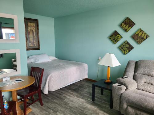 um quarto com uma cama, uma mesa e um sofá em Viking INN Clara City em Clara City