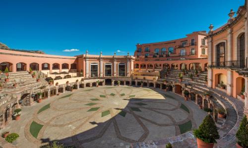 a courtyard with an umbrella in front of a building at Quinta Real Zacatecas in Zacatecas