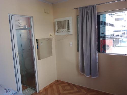 a small room with a shower and a window at Hostel Morais in Maceió