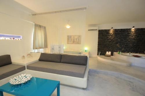 a living room with a couch and a table at Thea Luxury Resort in Fira