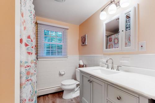a bathroom with a sink and a toilet and a window at Collingwood Cottage in Yarmouth Port