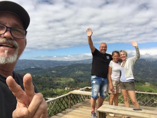 a group of people standing on a deck with their hands in the air at Bella Vista Ranch Ecolodge in Turrialba