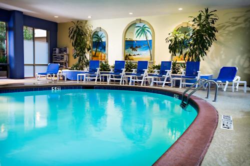 basen w hotelu z niebieskimi krzesłami w obiekcie Crowne Plaza Suites Arlington, an IHG Hotel w mieście Arlington