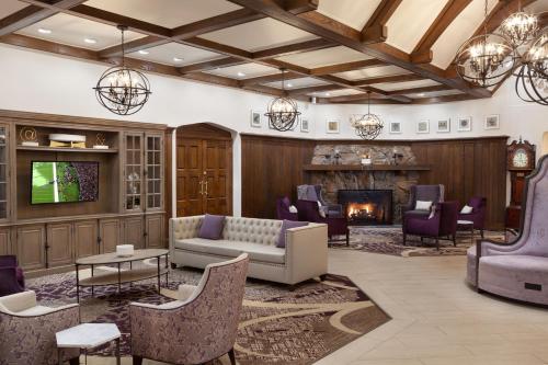 a lobby with a couch and chairs and a fireplace at The Grand Summit Hotel in Summit