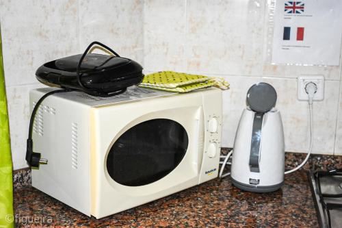 a microwave sitting on a counter next to a blender at Terra Chã Cottage,FEEL Home, in São Vicente