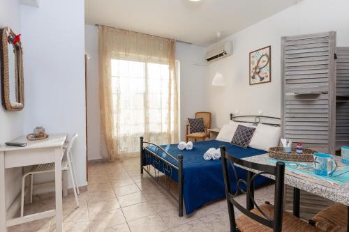 a bedroom with a bed and a table in a room at Kampus Living Luxury Complex in Faliraki