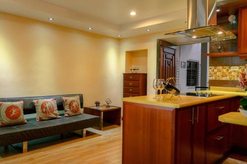 a kitchen with a couch and a sink and a counter at Fantástico Loft Centro Histórico Quito in Quito