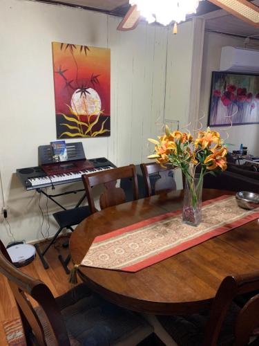 a dining room table with a vase of flowers and a keyboard at Hospedaje Familiar Glady's House in Puerto Montt