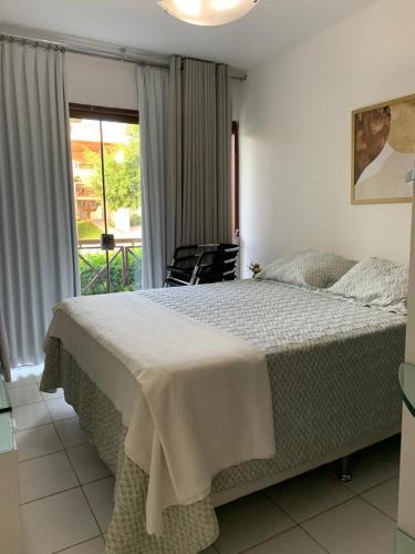 a bedroom with a large bed and a balcony at Monte Castelo Gravatá in Gravatá