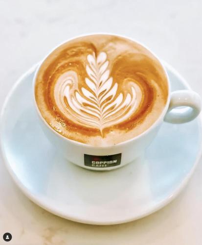a cup of coffee on a plate on a table at Art Hotel in Kralendijk