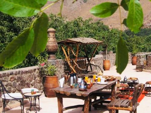 une table et des chaises en bois avec une table dans l'établissement Riad imlil, à Imlil