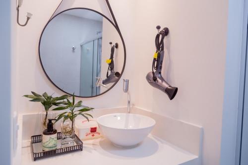 a bathroom with a white sink and a mirror at Ipanema 309 Studio in Rio de Janeiro