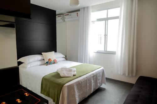ein Schlafzimmer mit einem Bett mit einer grünen Decke und einem Fenster in der Unterkunft Ipanema 309 Studio in Rio de Janeiro