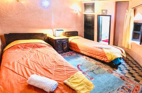 two beds sitting next to each other in a bedroom at Riad imlil in Imlil