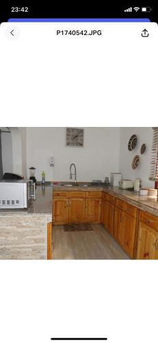 a kitchen with wooden cabinets and a sink at Ogumka, Self catering , Beoliere, Mahe in Victoria