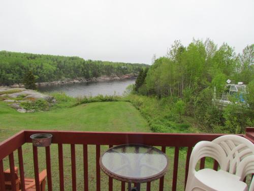 a balcony with a view of a river at Les Chalets au Bord de la Mer in Les Escoumins