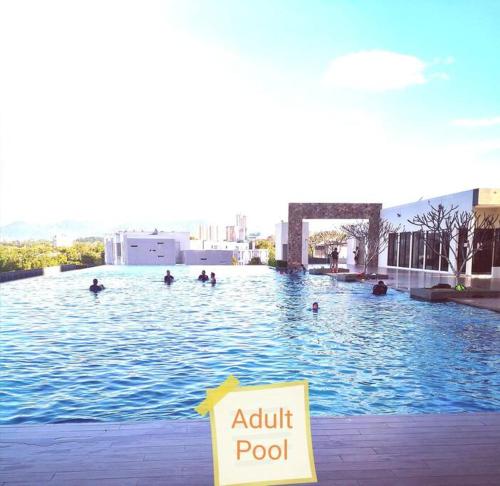 a pool with people swimming in the water at NiDaHomeStay Nilai USIM KLIA WiFi androidtv full aircond in Nilai