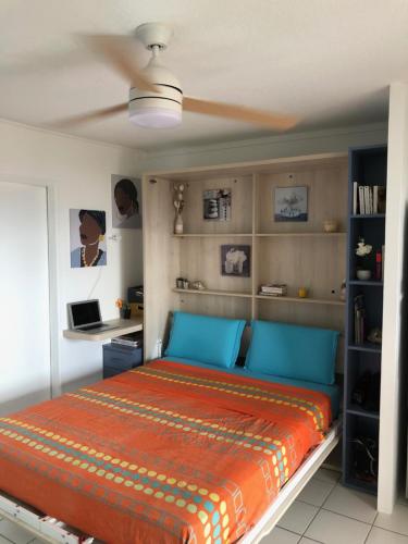 una camera con letto e lenzuola blu e arancioni di Studio de charme VUE MER 2 personnes ENTIEREMENT RENOVÉ a Les Trois-Îlets