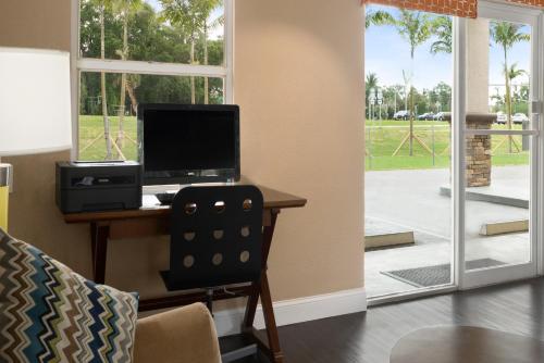 a room with a desk with a computer and a chair at Super 8 by Wyndham Ellenton Bradenton Area in Ellenton